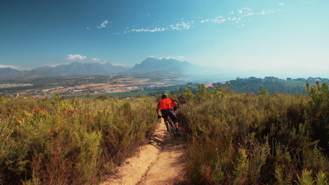 High angle view of mountain biker riding a dirt path downhill