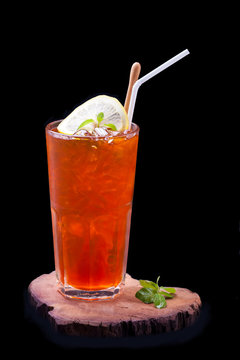 tea cocktail with lemon and ice on a black background