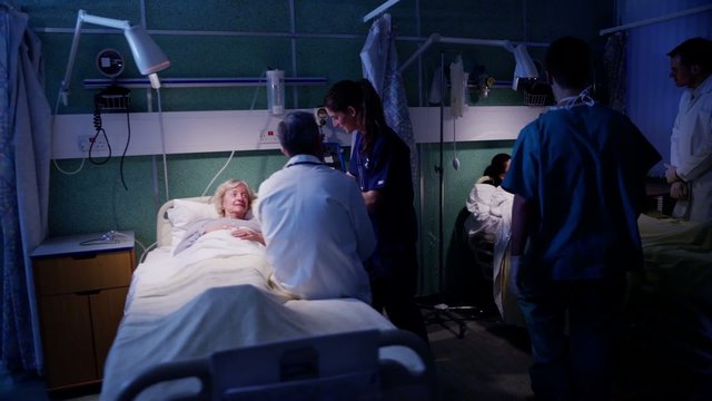 Medical team working together at night, taking care of patients on hospital ward