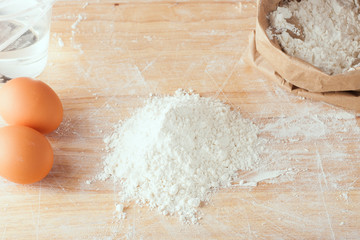 flour and eggs on wooden board