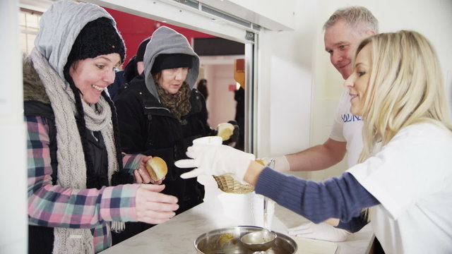 Soup kitchen volunteers help to feed the homeless