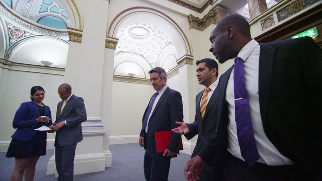 Business or political delegates chat as they walk through conference building