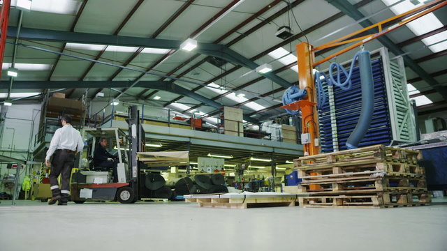 Time lapse of busy warehouse workers lifting and moving goods and materials