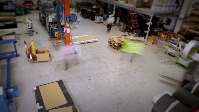 Time lapse clip of busy warehouse or factory workers