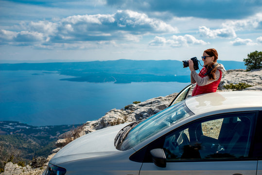 Woman Photographer With Car On The Top Of Mountain