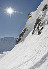 Snowboarder springt von einem Felsen