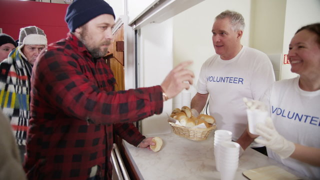Soup kitchen volunteers help to feed the homeless