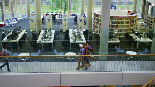 Diverse student group walking through a large modern university building.