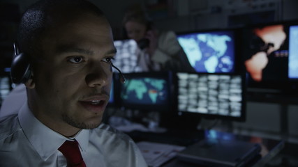 Security personnel working in system control room. - Powered by Adobe