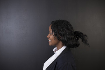 African or African American woman teacher on blackboard