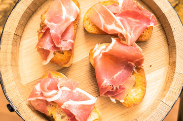 Tapas with jamon on a wooden barrel