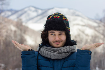 portrait of a man in a hat on a background of mountains