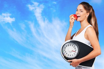 Exercising. Beautiful young woman holding measuring instrument