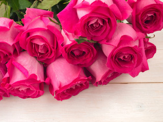 Heap of pink roses on the planks background