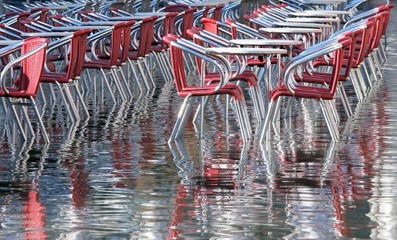 reflection on the water table and chairs in Venice during the fl