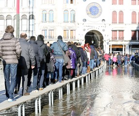 People walking on the catwalk in Venice during at high tide