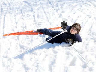 young boy asks for help after the fall on skis