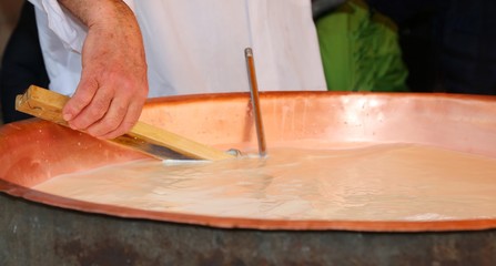 cheesemonger and check the temperature of the boiling milk in th