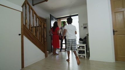 Loving father returns home from a trip to be greeted by his family