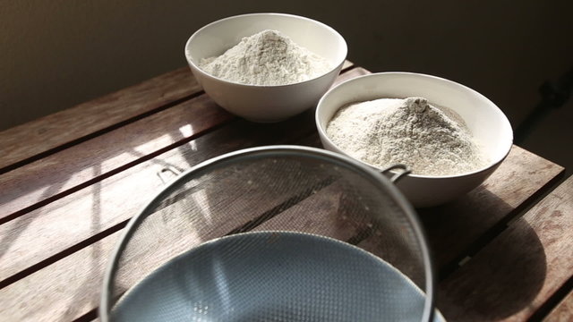 closeup of wheat and rye flour and bolter standing on wooden tab