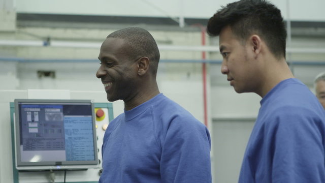 Happy mixed ethnicity team of machine operators in a factory