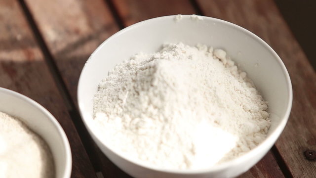 closeup of wheat and rye flour in white plates standing on woode