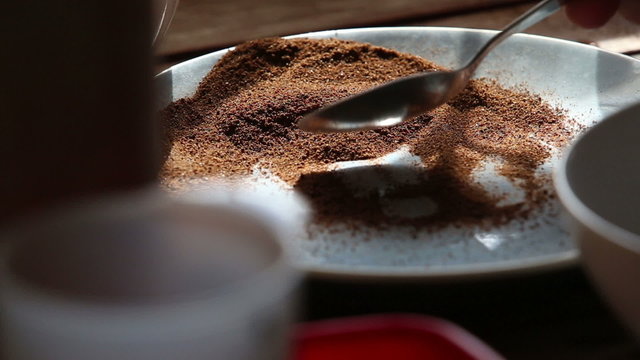 caucasian woman hand puts malt powder with spoon into plate clos