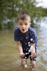 Young boy playing in the river splashing