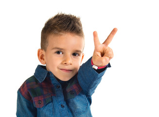 Kid doing victory gesture over white background