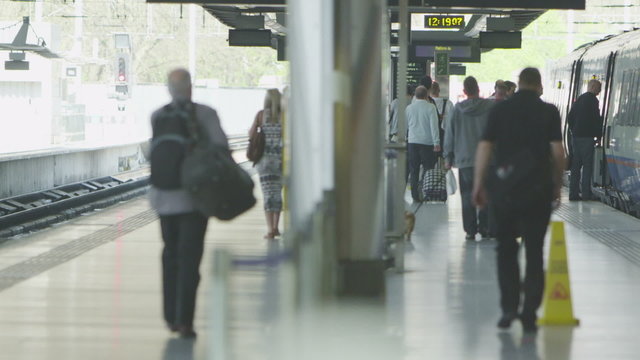 Travelers and commuters on the platform at St. Pancras railway station, London