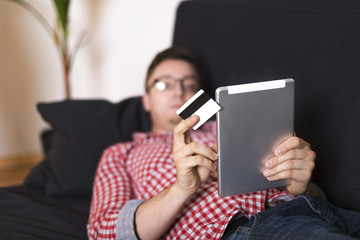 Man relaxing on sofa buying online