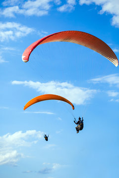 Paraglider flying on blue sky