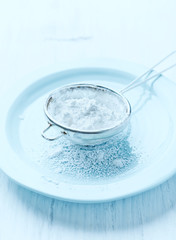 Sieve with icing sugar on a plate