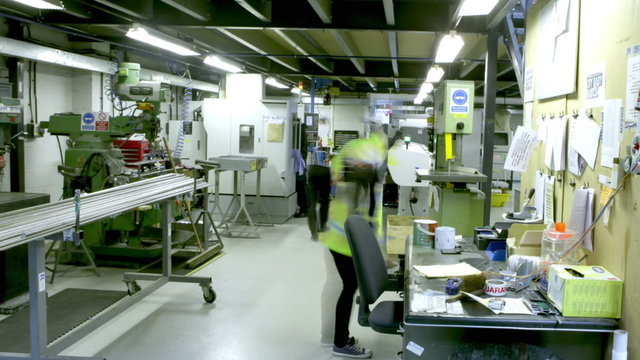 Time lapse of busy workers in the office section of a warehouse or factory