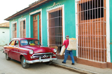 Streets of Trinidad, Cuba. Man delivering bread and old classic