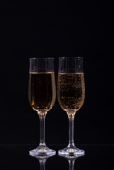 two glasses of champagne over black background
