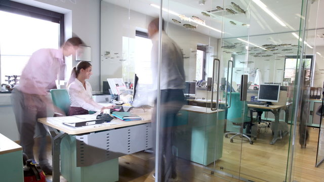 Time lapse of busy business group working in contemporary office building
