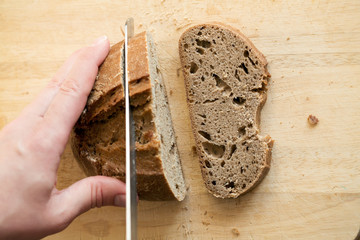 A hand cutting rye bread