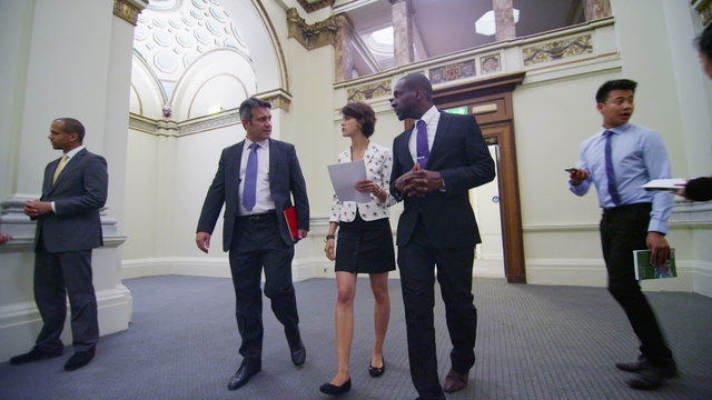 Business or political delegates chat as they walk through conference building