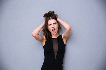 Naklejka premium Angry young woman over gray background