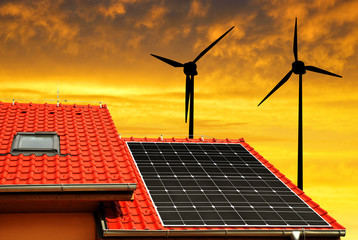Solar panel on the roof of the house and wind turbines