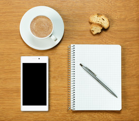 Smartphone, coffee, notepad and pen