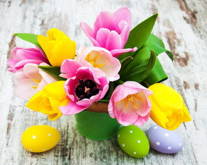 Bucket with colorful tulips and easter eggs