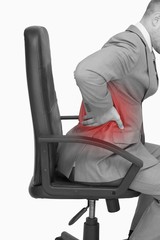 Business man with backache sitting in an office chair