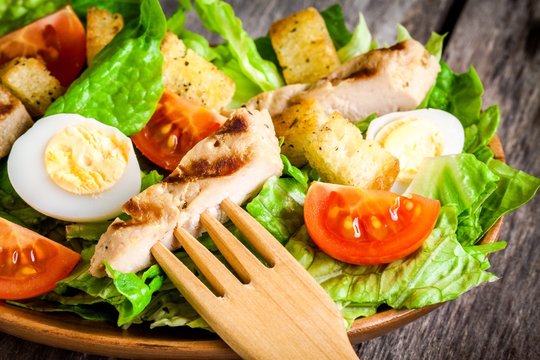 Caesar salad with cherry tomatoes and grilled chicken close up
