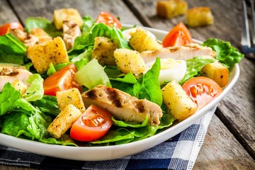 Caesar salad with croutons, quail eggs, and grilled chicken