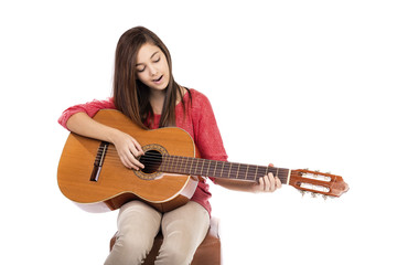 Pretty teenage girl singing a song while playing an acoustic gui