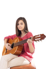 Pretty teenage girl playing an acoustic guitar