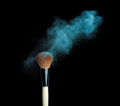 powderbrush on black background with blue powder splash