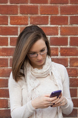 Young woman checking cell phone street